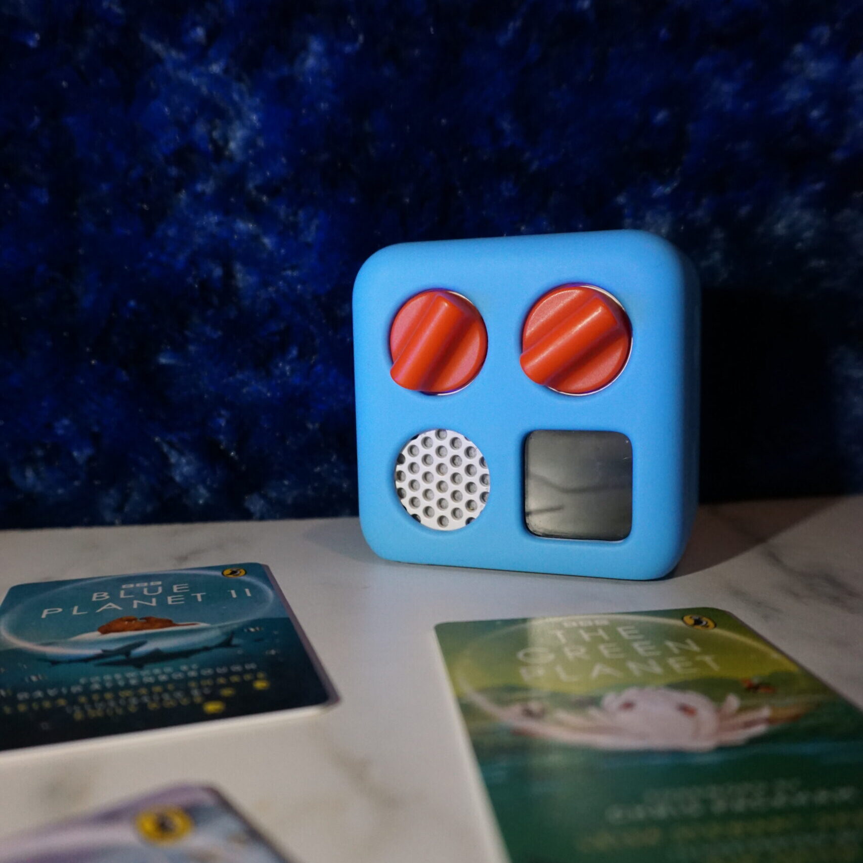 The Yoto Mini Player in a blue jacket, one of the best sensory toys for travel with autism.